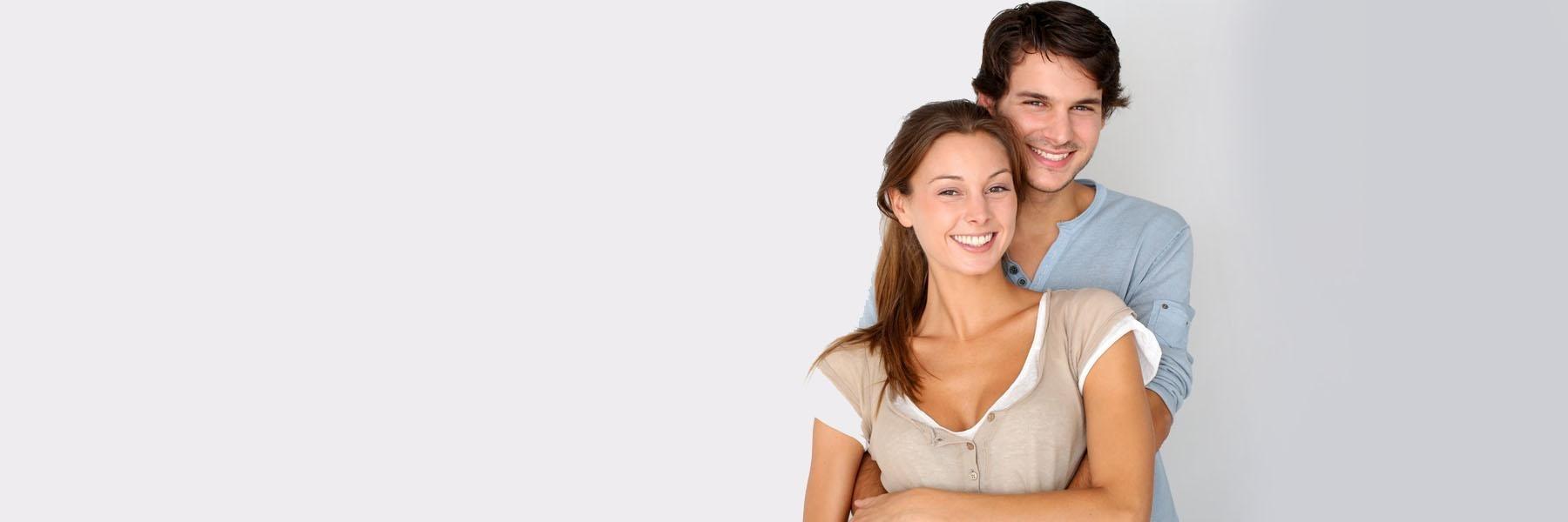 Young couple hugging & smiling l Porcelain Veneers Doylestown PA