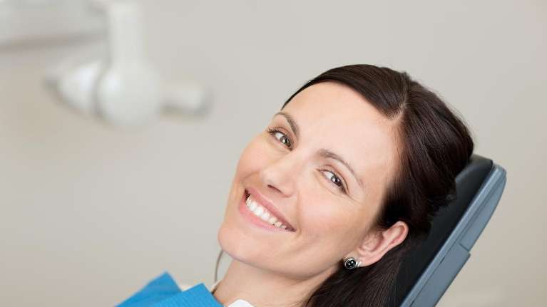 Female patient in Doylestown PA smiles after a dental implant procedure